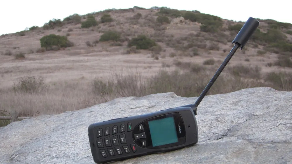 Iridium sat phone resting on a rock outdoors